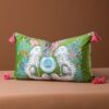 Green velvet lumbar pillow cover with white spaniel dogs, blue vase, and pink tassels.