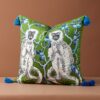 Forest green velvet cushion pillow cover with double-sided white monkeys, blue tree print, and blue tassels.