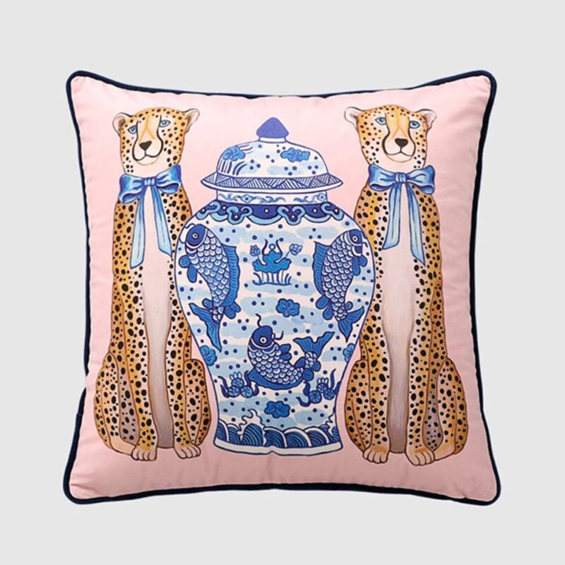 Light pink velvet cushion cover with orange leopards, blue ties, and a royal blue porcelain jar with a koi fish design.