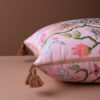 Pink velvet pillow cover with double-sided print of pink leopards, ceramic flower pot, white pigeons, butterflies, and rust tassels