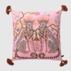 Pink velvet pillow cover with double-sided print of pink leopards, ceramic flower pot, white pigeons, butterflies, and rust tassels.